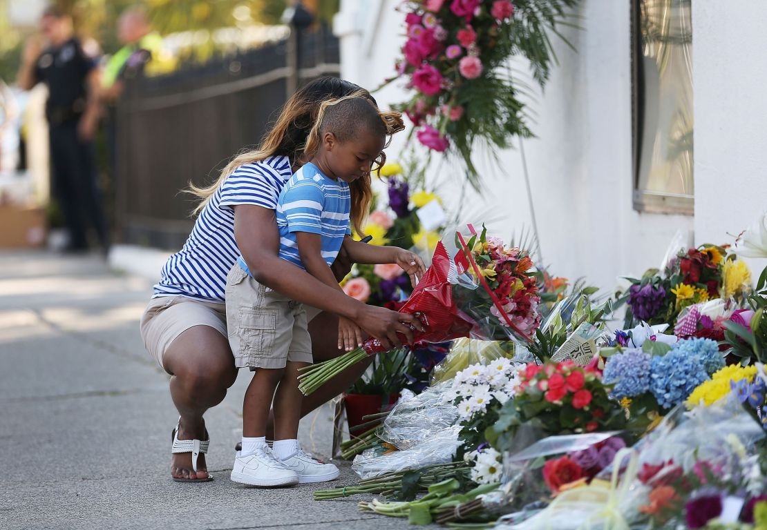Tamara Holmes and her son, Trenton, lay flowers in front of  Emanuel AME Church after a mass shooting in June 2015 that left nine people dead.