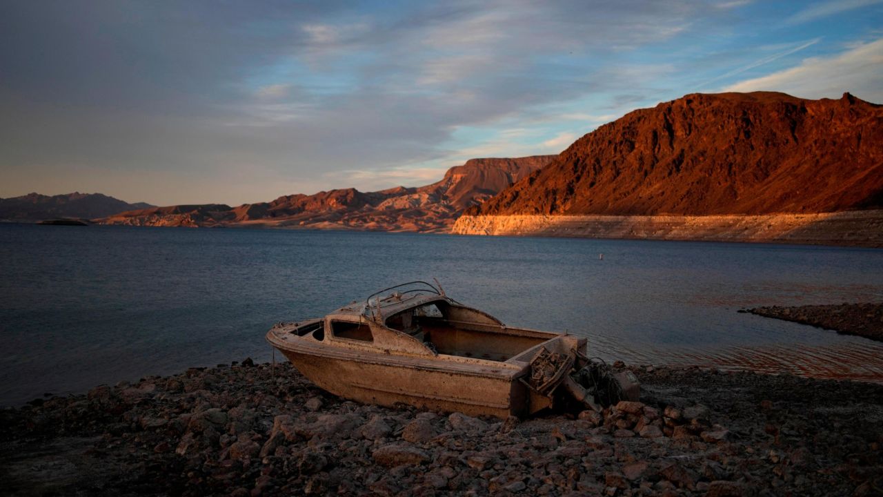 A formerly sunken boat sits high and dry along the receding shoreline of Lake Mead.