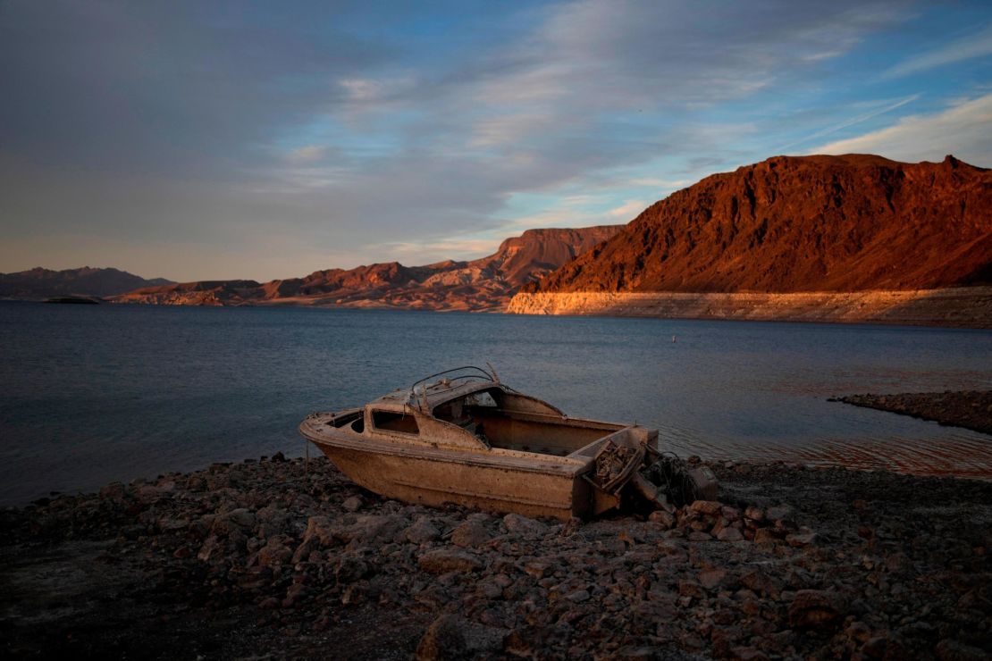 A formerly sunken boat sits high and dry along the receding shoreline of Lake Mead.
