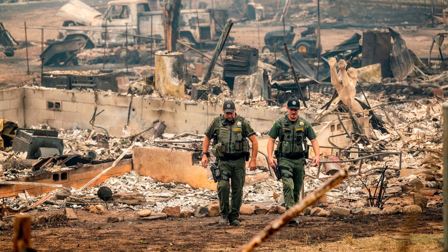 Sheriff's deputies leave a home where a victim of the McKinney Fire was found on Monday in Klamath National Forest.