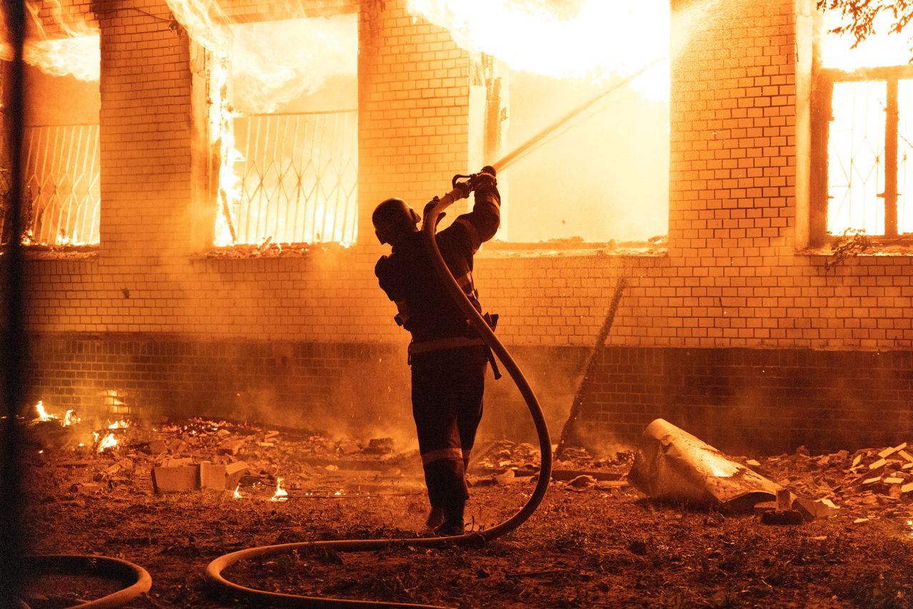 A firefighter extinguishes a burning hospital building hit by a <a target=