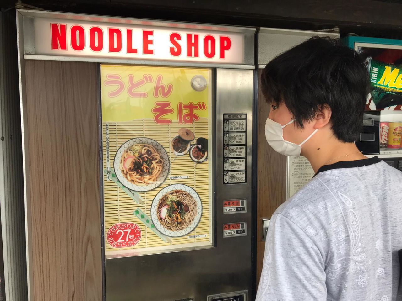 A visitor checks out the options on a noodle vending machine.