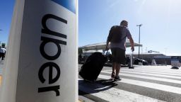 A passenger walks near Uber signage after arriving at Los Angeles International Airport (LAX) in Los Angeles, California, U.S. July 10, 2022. 