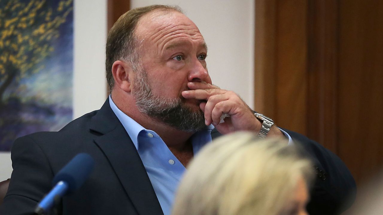 Alex Jones attempts to answer questions about his text messages asked by Mark Bankston, lawyer for Neil Heslin and Scarlett Lewis, during trial at the Travis County Courthouse in Austin, Wednesday Aug. 3, 2022. Jones testified Wednesday that he now understands it was irresponsible of him to declare the Sandy Hook Elementary School massacre a hoax and that he now believes it was "100% real."