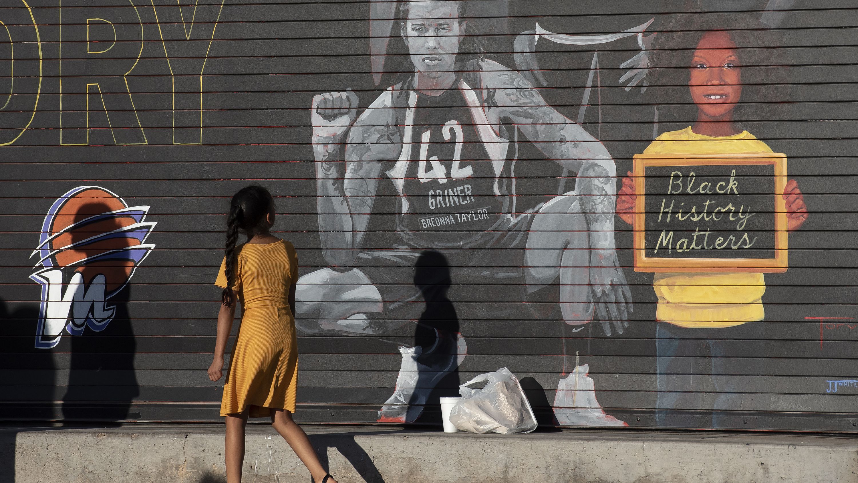 A girl walks past a Griner mural in Phoenix in April 2022. Griner had been arrested in Russia a couple of months earlier.