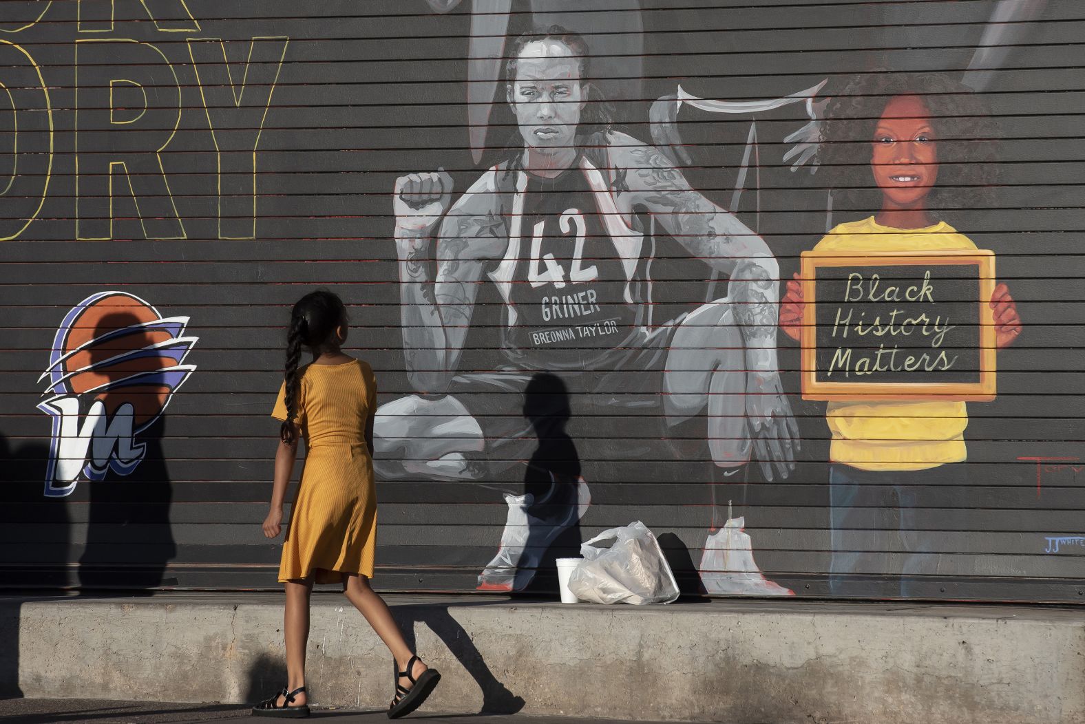 A girl walks past a Griner mural in Phoenix in April 2022. Griner had been arrested in Russia a couple of months earlier.
