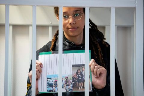 Griner holds photographs standing inside a defendants' cage before a hearing on July 26, 2022.