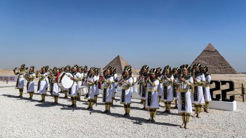Marching band members dressed in ancient Egyptian clothing perform ahead of the 2022 Pyramids Air Show at the Giza Pyramids Necropolis on the southwestern outskirts of Egypt's capital Cairo on August 3.  