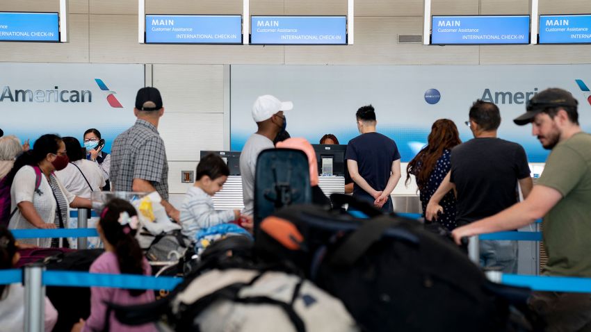 Travelers wait in line at an American Airlines counter at Ronald Reagan Washington National Airport in Arlington, Virginia, on July 2, 2022.