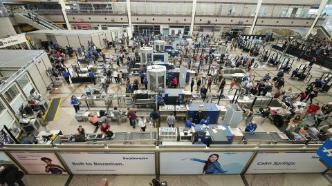 Travelers line up at Denver International Airport on the Thursday before Memorial Day this year. A jump in canceled flights, especially during holiday weekends, has combined with high fares to make this a difficult summer travel season for passengers.