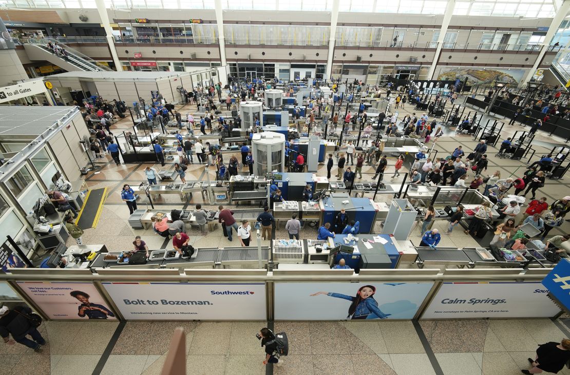 Travelers line up at Denver International Airport on the Thursday before Memorial Day this year. A jump in canceled flights, especially during holiday weekends, has combined with high fares to make this a difficult summer travel season for passengers.