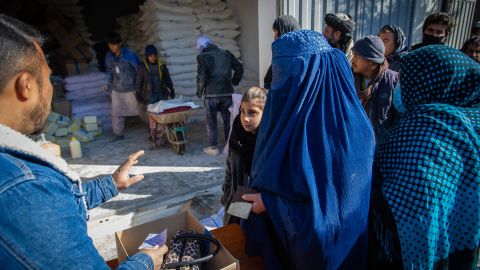 Una donna afgana raccoglie la razione mensile di alimenti di base della sua famiglia da un punto di distribuzione del Programma alimentare mondiale nel distretto di Jaie Rais, nella parte occidentale di Kabul.