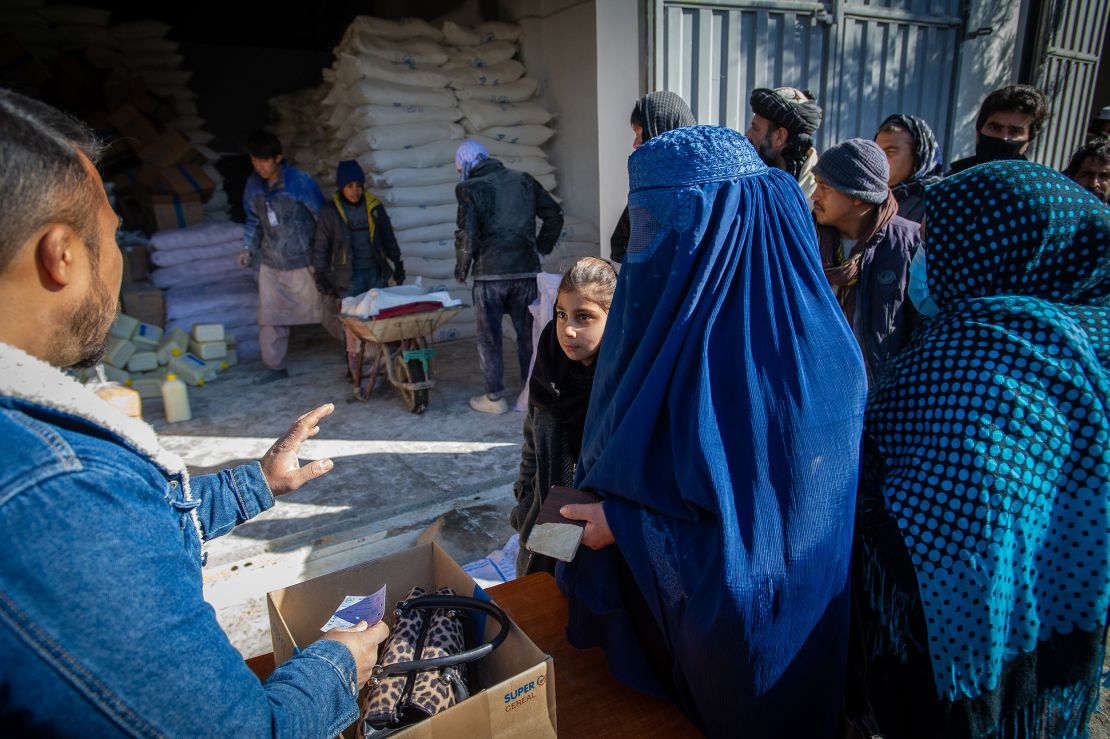 An Afghan woman collects her family's monthly ration of staple foods from a World Food Programme distribution point in the Jaie Rais district of western Kabul.