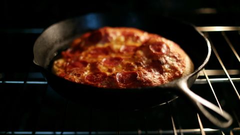 Preheating a cast iron skillet in the oven gives the dough a sizzling surface that helps the pizza puff up.
