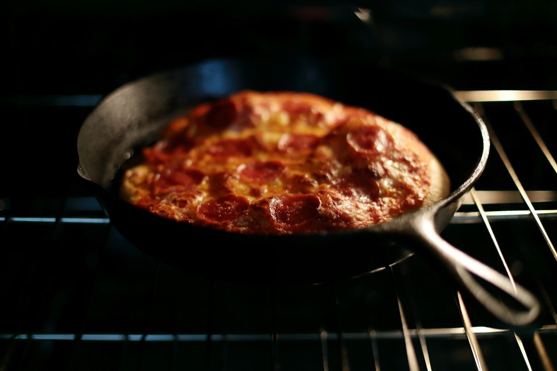 Preheating a cast-iron skillet in the oven gives dough a sizzling surface that helps the pizza puff up.