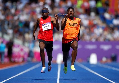 Namibia's Ananias Shikongo runs with his guide during a 100-meter race at the Commonwealth Games on Wednesday, August 3.