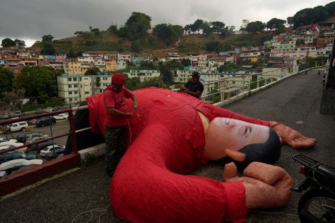 Supporters of the late Venezuelan President Hugo Chavez bring down an inflatable doll of Chavez after commemorating what would have been his 68th birthday Thursday, July 28, in Caracas.