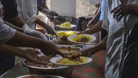 Volunteers serve free meals to people in need at a community kitchen in Colombo, Sri Lanka, August 4.