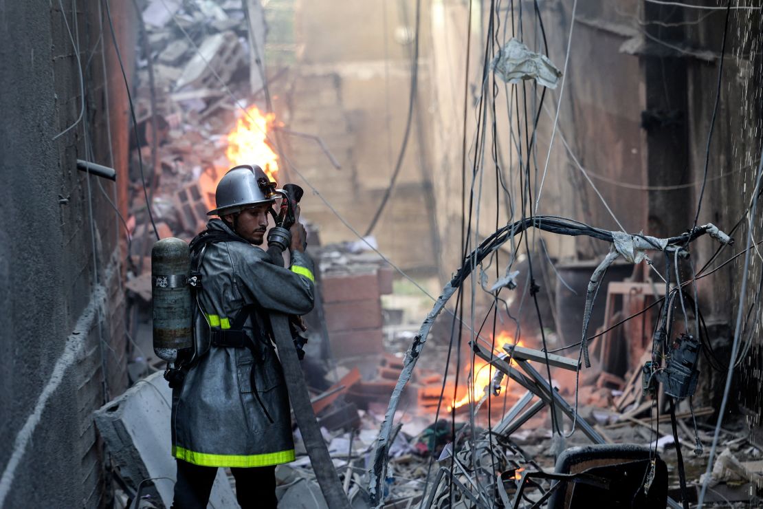 A Palestinian firefighter fights the blaze amid the destruction following an Israeli air strike on Gaza City, on August 5, 2022.