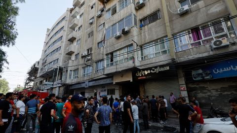 金曜日、ガザ市のイスラエルの攻撃現場の隣に集まるパレスチナ人。