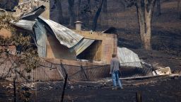 A man looks around property where a house was destroyed by the McKinney Fire in the Klamath National Forest near Yreka, California, on August 3, 2022. - At least four people are now known to have died in a wildfire sweeping through California, authorities said on August 2, as they warned the toll from the state's worst blaze this year could rise further. The fire, which is burning in the Klamath National Forest near the border with Oregon, is California's largest this year, having consumed around 56,000 acres (22,600 hectares). 