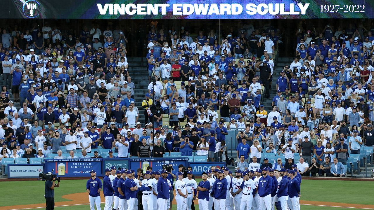 Los Angeles Dodgers players and coaches stand on the field as Vin Scully is honored during a pregame ceremony.