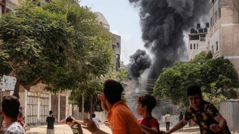 People run for cover during an airstrike in Gaza City on Saturday.