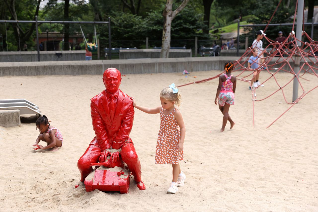 Children play nearby artist James Colomina's sculpture of Vladimir Putin in Central Park.