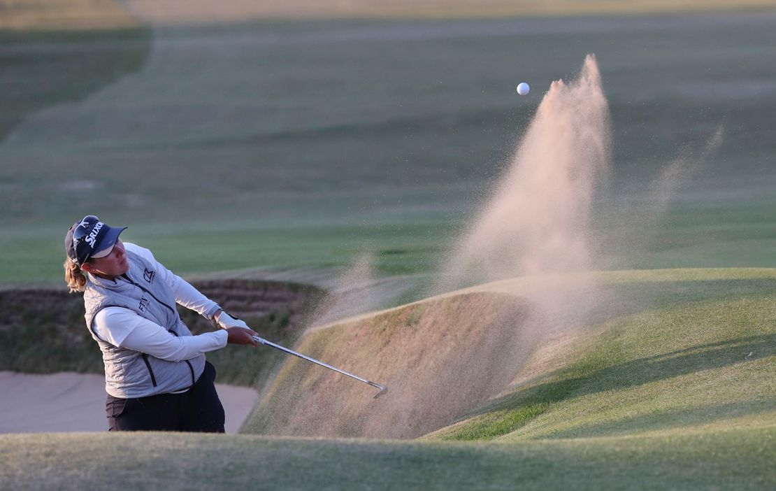 Buhai plays a shot from the bunker to set up her winning putt.