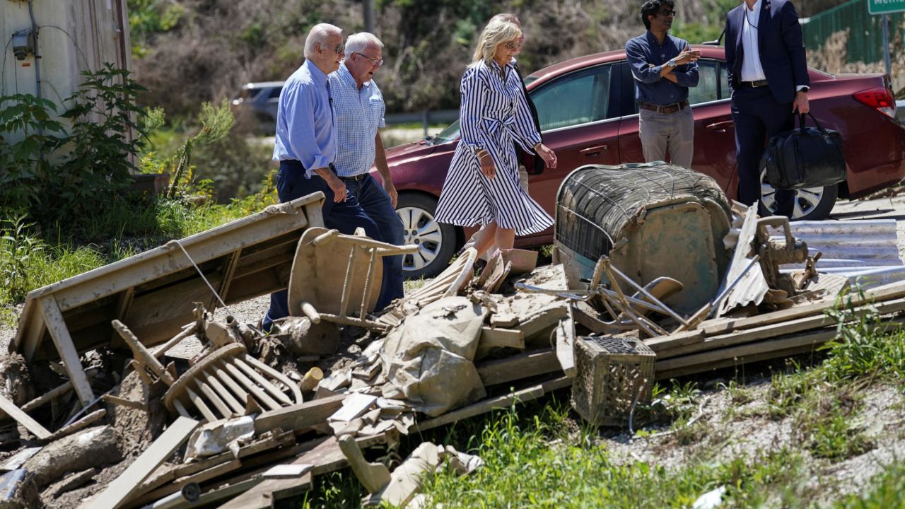 U.S. President Joe Biden and first lady Jill Biden walk past debris while viewing flood damage and response efforts in Lost Creek, Kentucky, U.S., August 8, 2022. REUTERS/Kevin Lamarque