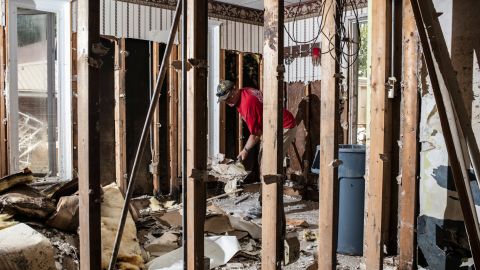 A friend helps tear out drywall at Sam Quillen's damaged property in Fleming-Neon, Kentucky.