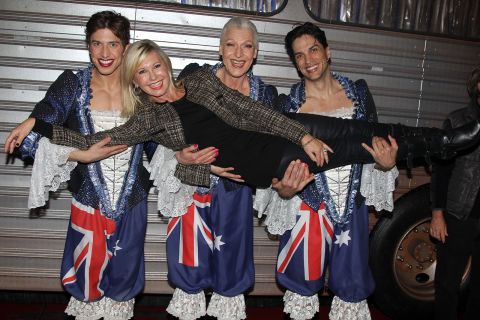 Newton-John is held by Nick Adams, Tony Sheldon and Will Swenson while attending the Broadway musical 