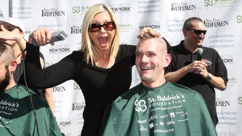 Newton-John shaves the head of Greg Chase, director of guest experience at the New York-New York Hotel & Casino, during a fundraiser in Las Vegas in 2015.