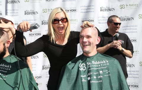 Newton-John shaves the head of Greg Chase, director of guest experience at the New York-New York Hotel & Casino, during a fundraiser in Las Vegas in 2015.