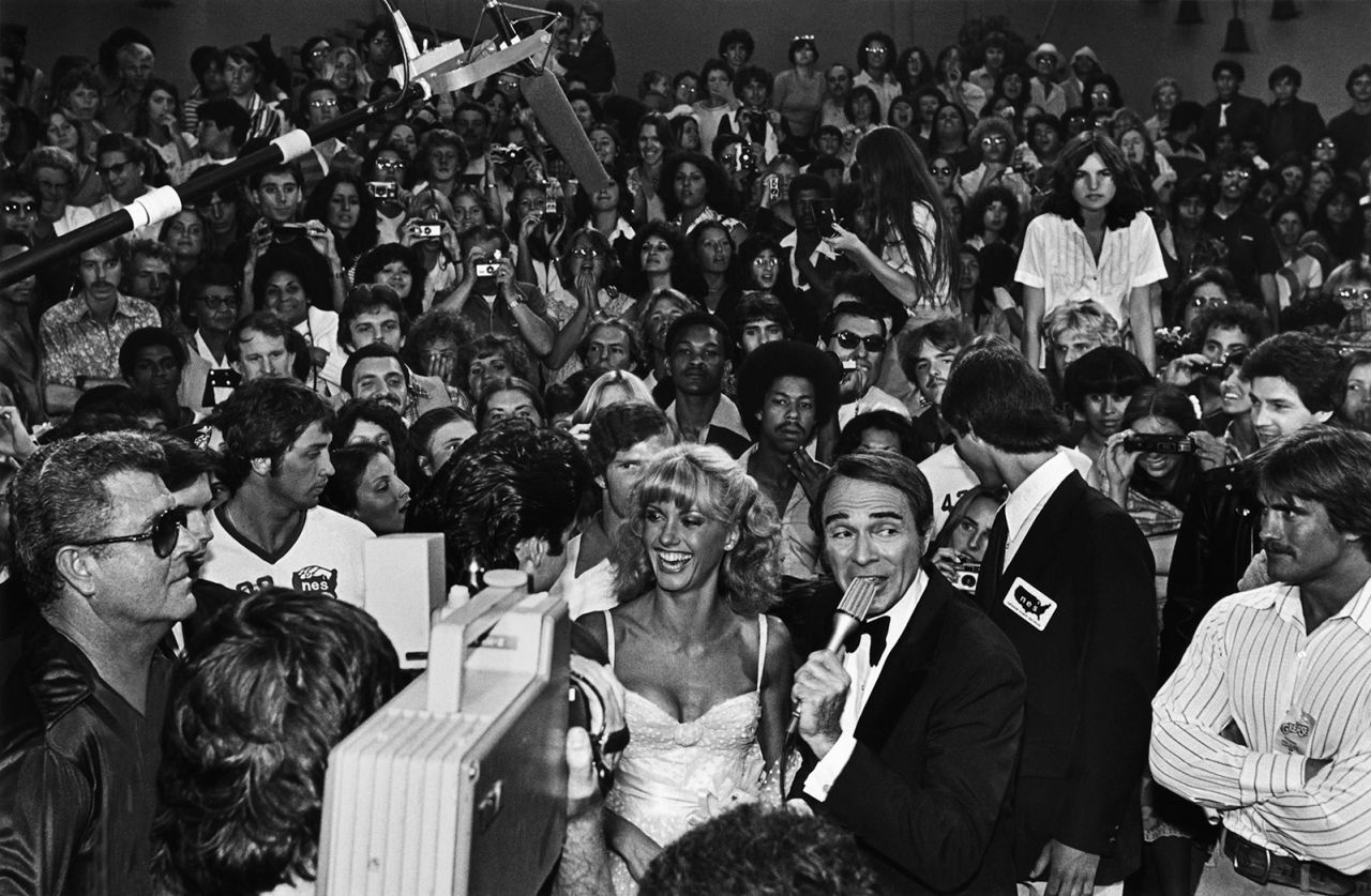 Newton-John is interviewed on the red carpet at the Hollywood premiere of "Grease."