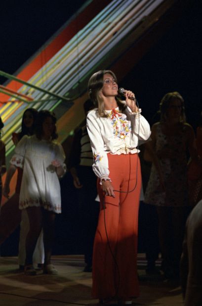 A '70s embroidered blouse and red wide-leg trousers make up Newton-John's look during a "Top of the Pops" appearance. 