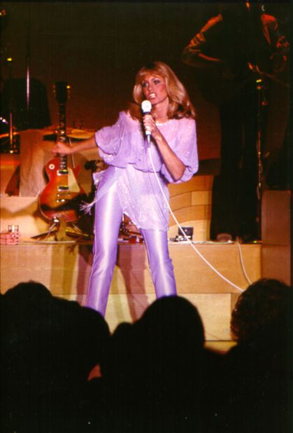 Newton-John in an all-violet number during a performance circa 1970. 