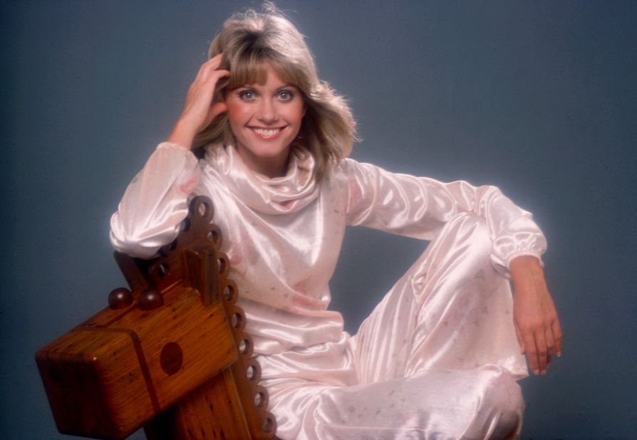 Newton-John poses with a wooden rocking horse in a luminous dress for a promotional photo for the 1976 ABC broadcast "A Special Olivia Newton-John."