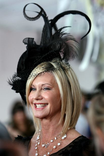 Newton-John poses in a striking headpiece for a day at the races in Melbourne in 2009 where she also performed. 