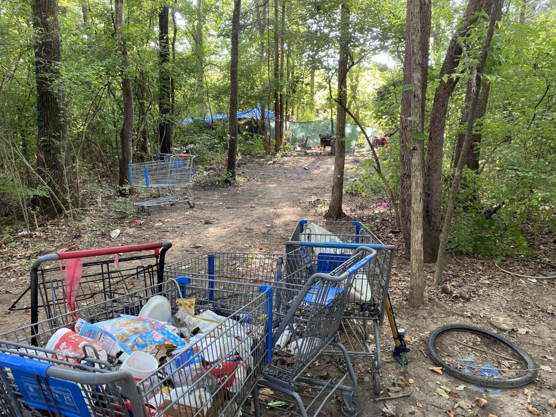A homeless encampment in Nashville is littered with shopping carts and trash.