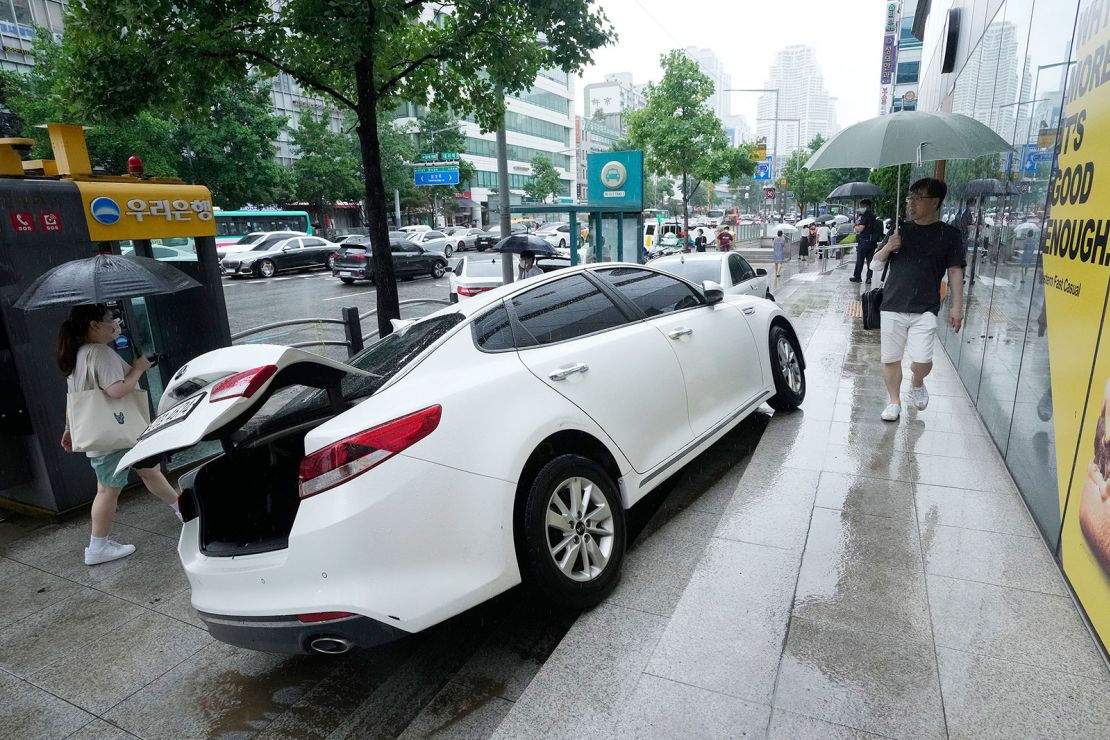 A vehicle is damaged on the sidewalk after floating in heavy rainfall in Seoul, South Korea on August 9.