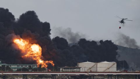 A firefighter helicopter drops water on a massive fire at a fuel depot in Matanzas, Cuba, on August 8.