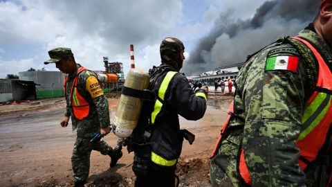 Mexican and Cuban firefighters work to put out the fire at the fuel depot that was sparked by a lightning strike.