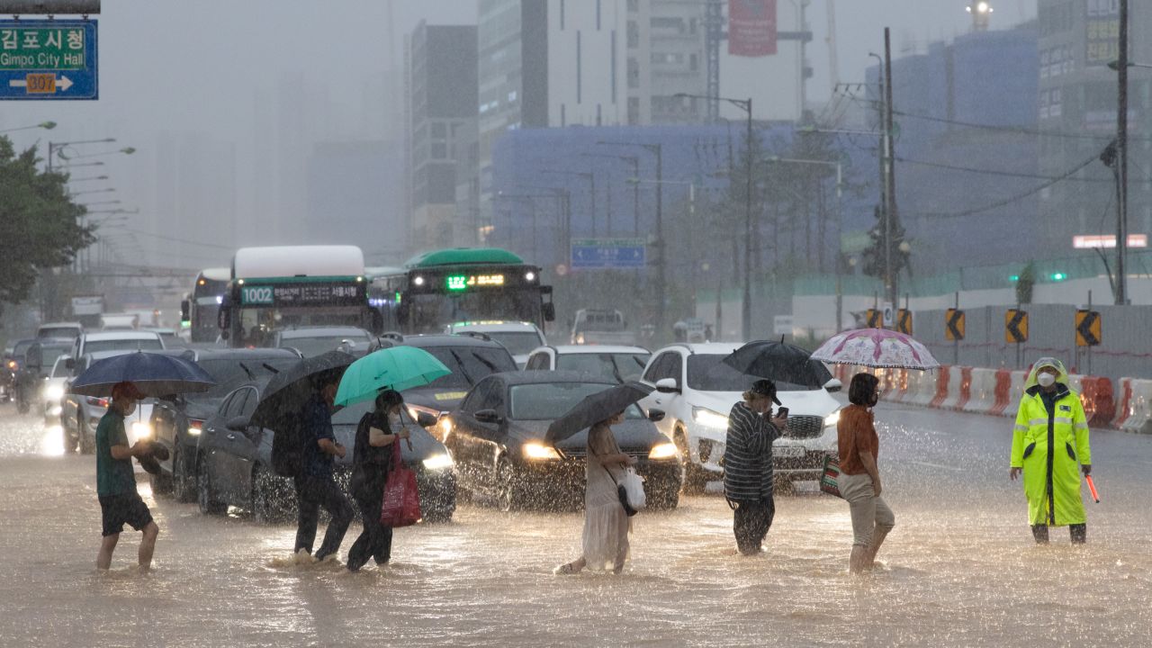 Pedestrians cross a flooded road in Gimpo, Seoul, on  August 9.
