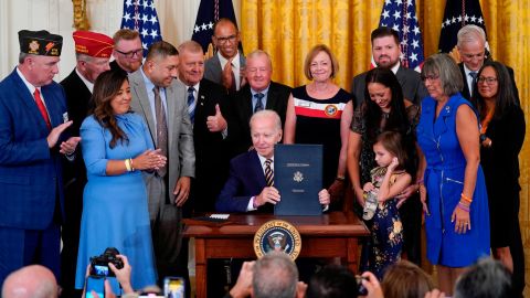 President Joe Biden holds the "PACT Act of 2022" after signing it during a ceremony in the East Room of the White House, Wednesday, Aug. 10, 2022, in Washington. (AP Photo/Evan Vucci)