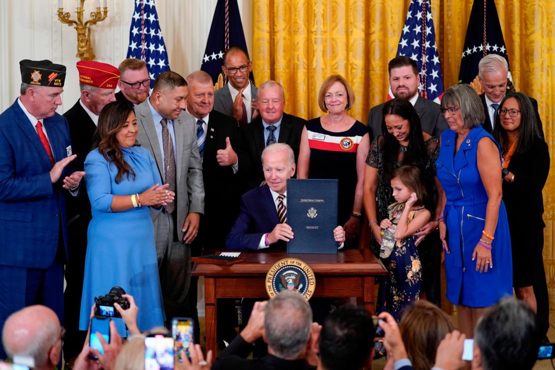 President Joe Biden holds the "PACT Act of 2022" after signing it during a ceremony in the East Room of the White House, Wednesday, Aug. 10, 2022, in Washington. (AP Photo/Evan Vucci)