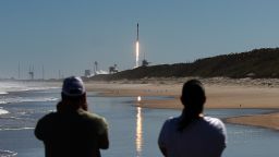 People watch from Canaveral National Seashore as a SpaceX Falcon 9 rocket launches from pad 39A at the Kennedy Space Center in Cape Canaveral, Florida. The rocket is carrying 49 Starlink internet satellites for a broadband network.