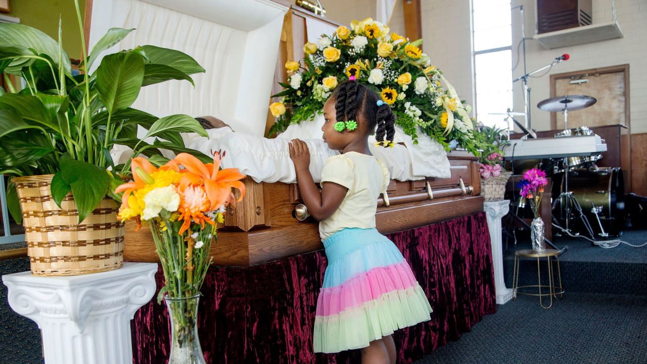 Michelle Cusseaux's 3-year-old niece looks in her casket during funeral services in 2014.