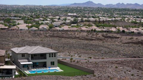 A home with a swimming pool abuts the desert on the edge of the Las Vegas valley in Henderson, Nevada. Officials are considering capping the size of new swimming pools because of the drought.