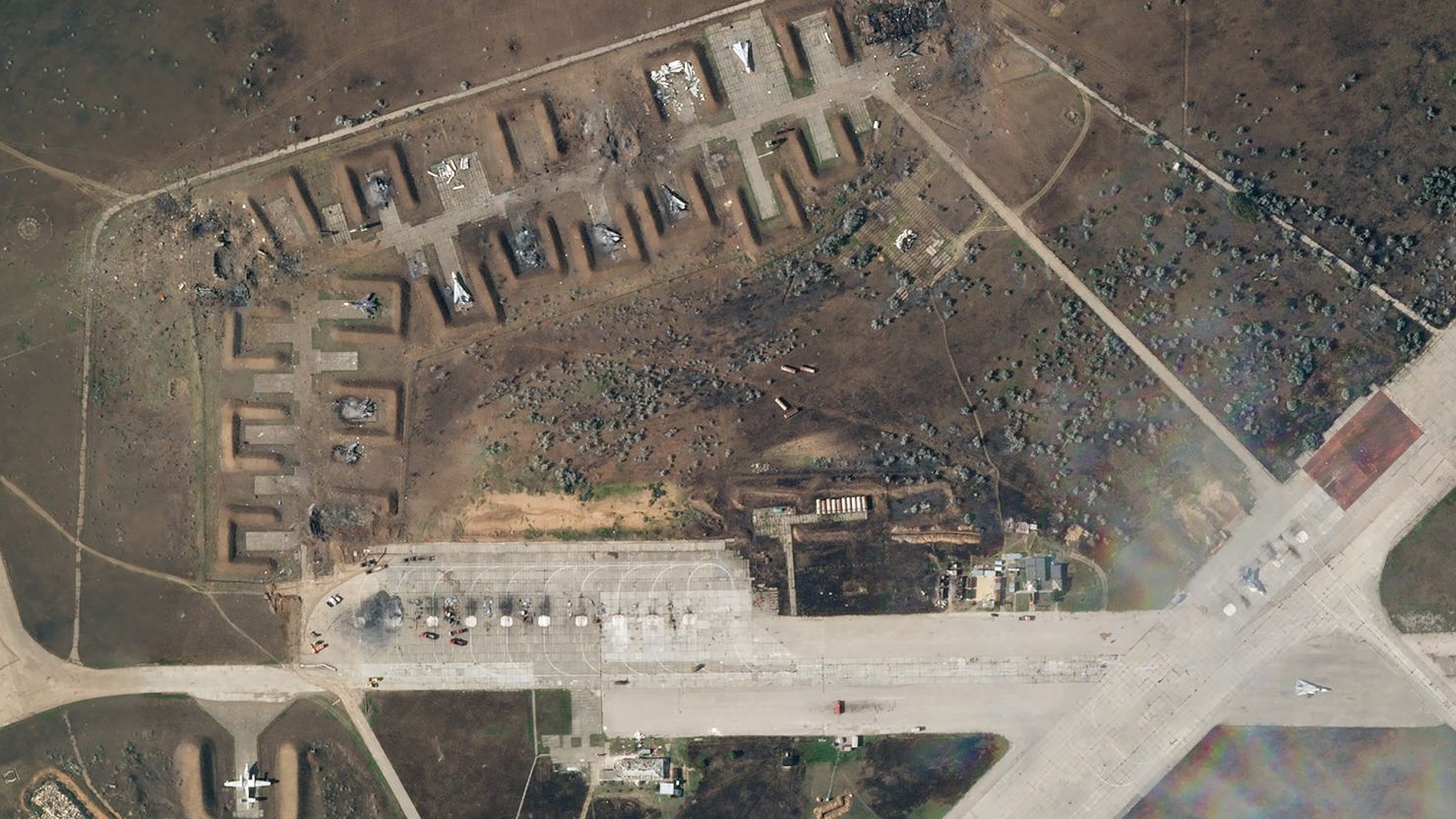 A satellite image from August 10, after the explosion, shows the charred remains of at least seven aircraft in the earthen berms.  